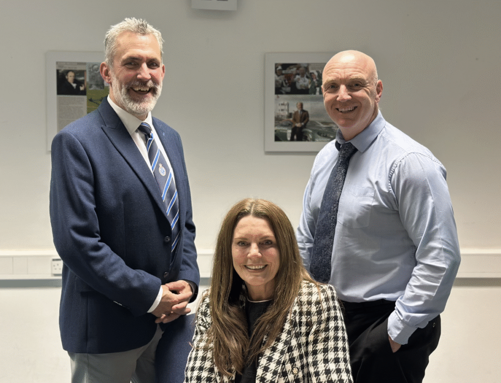 Kay Bennett is pictured smiling with branch chair Phil Walker and secretary Mike George. They are all wearing formal clothing.