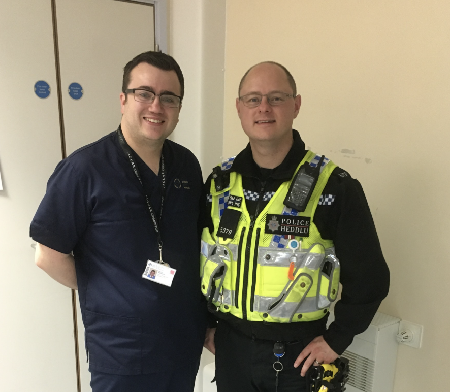 Dave - in blue hospital scrubs, and Phil - in police uniform stand together