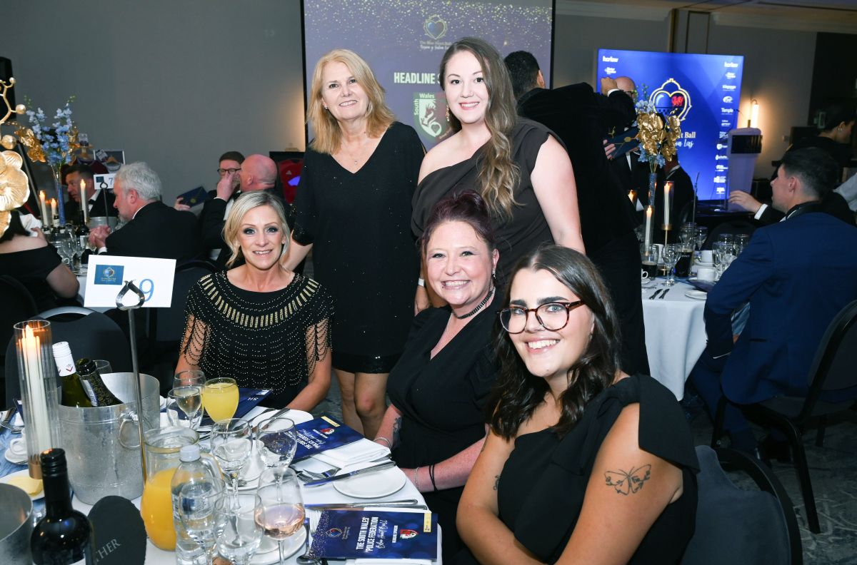 Guests smile at their table at the blue heart ball