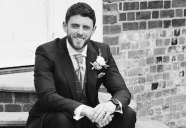 PC Andrew Harper dressed in his wedding suit smiles. The picture is black and white