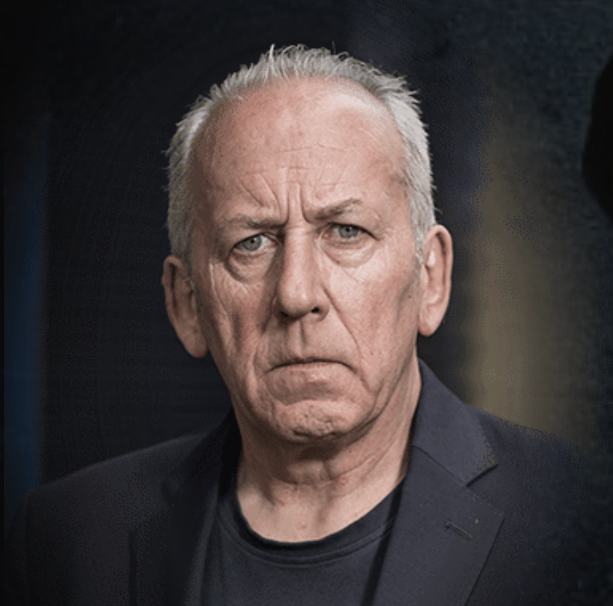 Peter Bleksley frowns and wears a black shirt and jacket